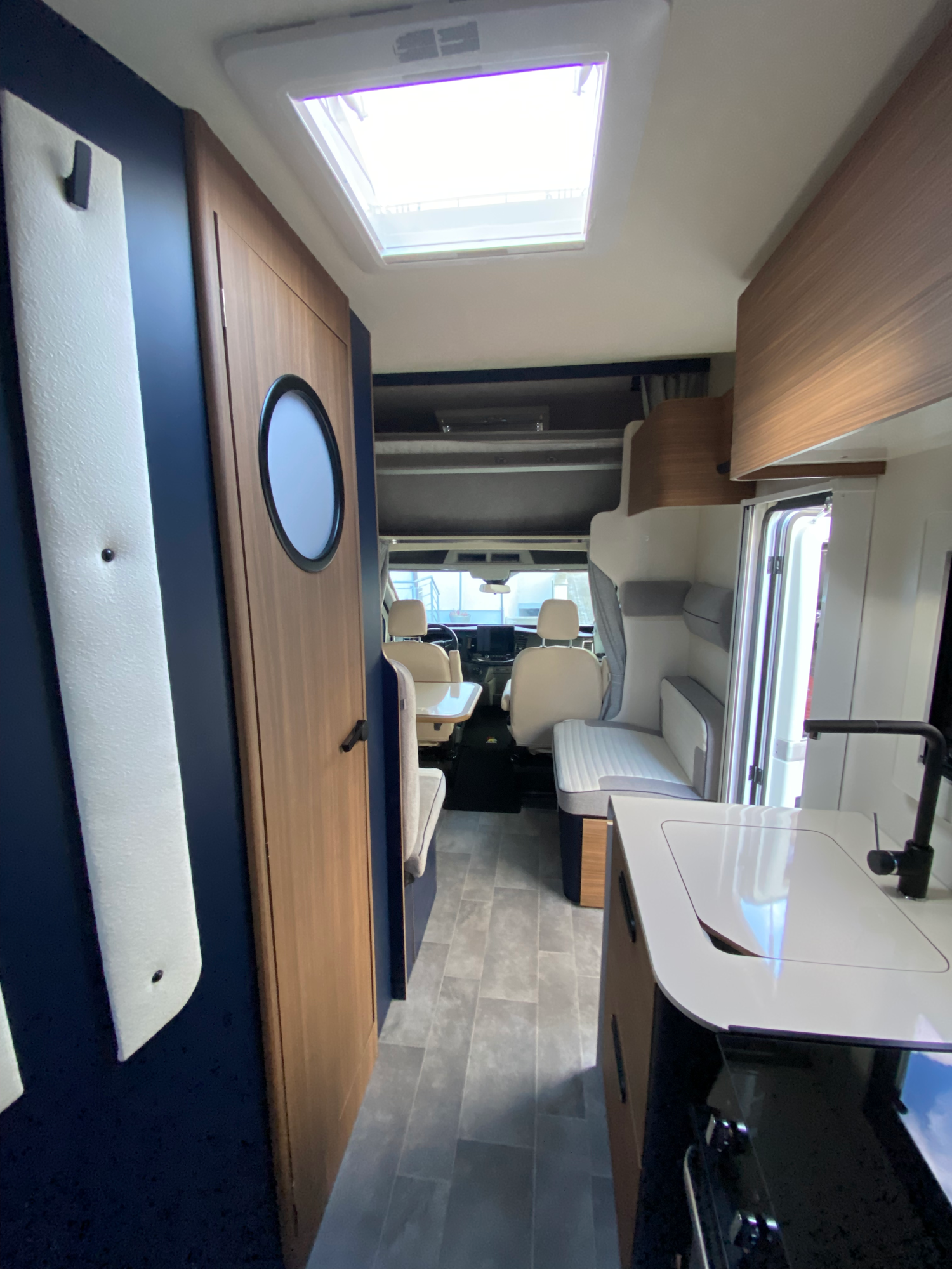 Küche & Sitzbereich Innenansicht eines Wohnmobils mit Blick auf die Sitze und Küchenausstattung.