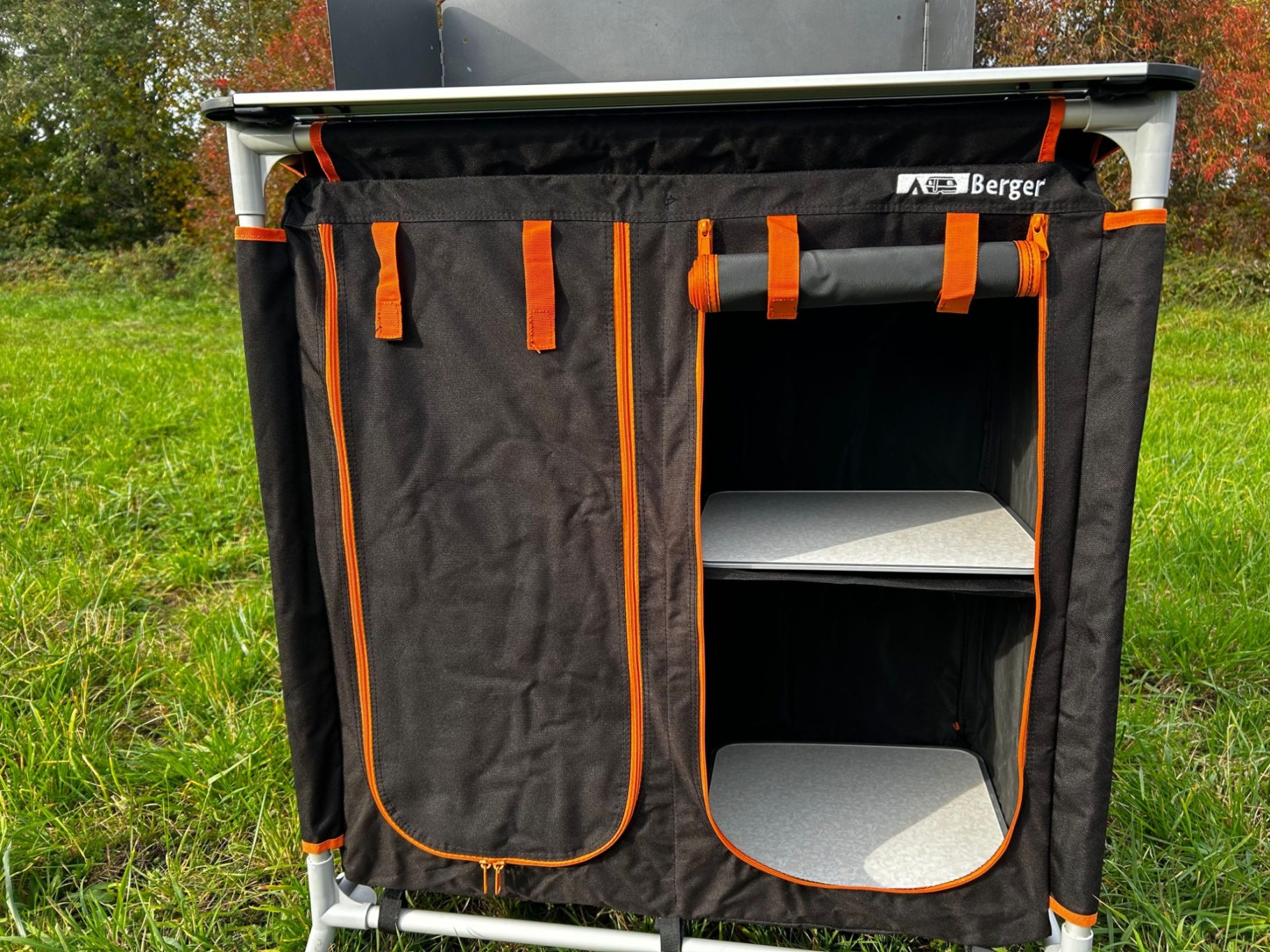 Fritz Berger Campingküche Schwarzer Campingregal mit orangefarbenen Akzenten und mehreren Fächern.