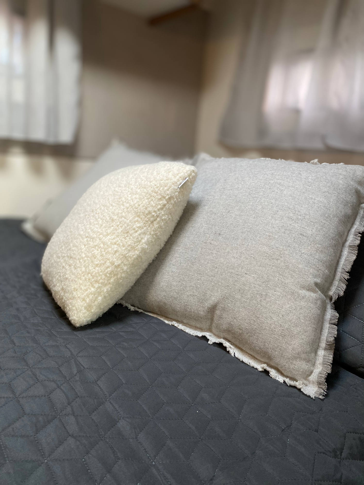 Gemütliches Heckbett mit 130x220cm Liegefläche Zwei Kissen, eines grau und eines weiß, liegen auf einem Bett mit grauer Bettwäsche.