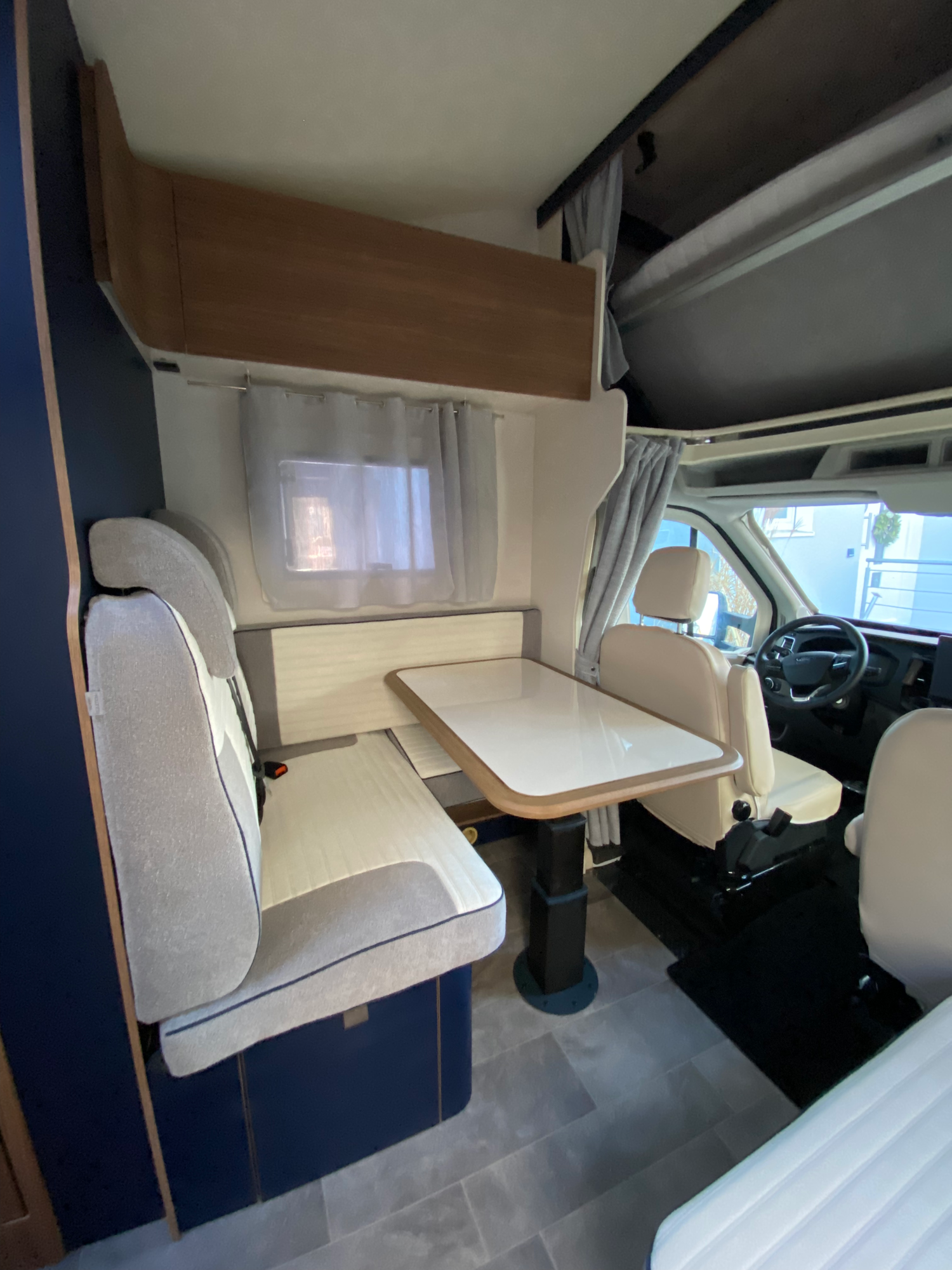 Die große, gemütliche Sitzgruppe Kompakter Wohnbereich mit Esstisch und Sitzgelegenheiten in einem Wohnmobil.