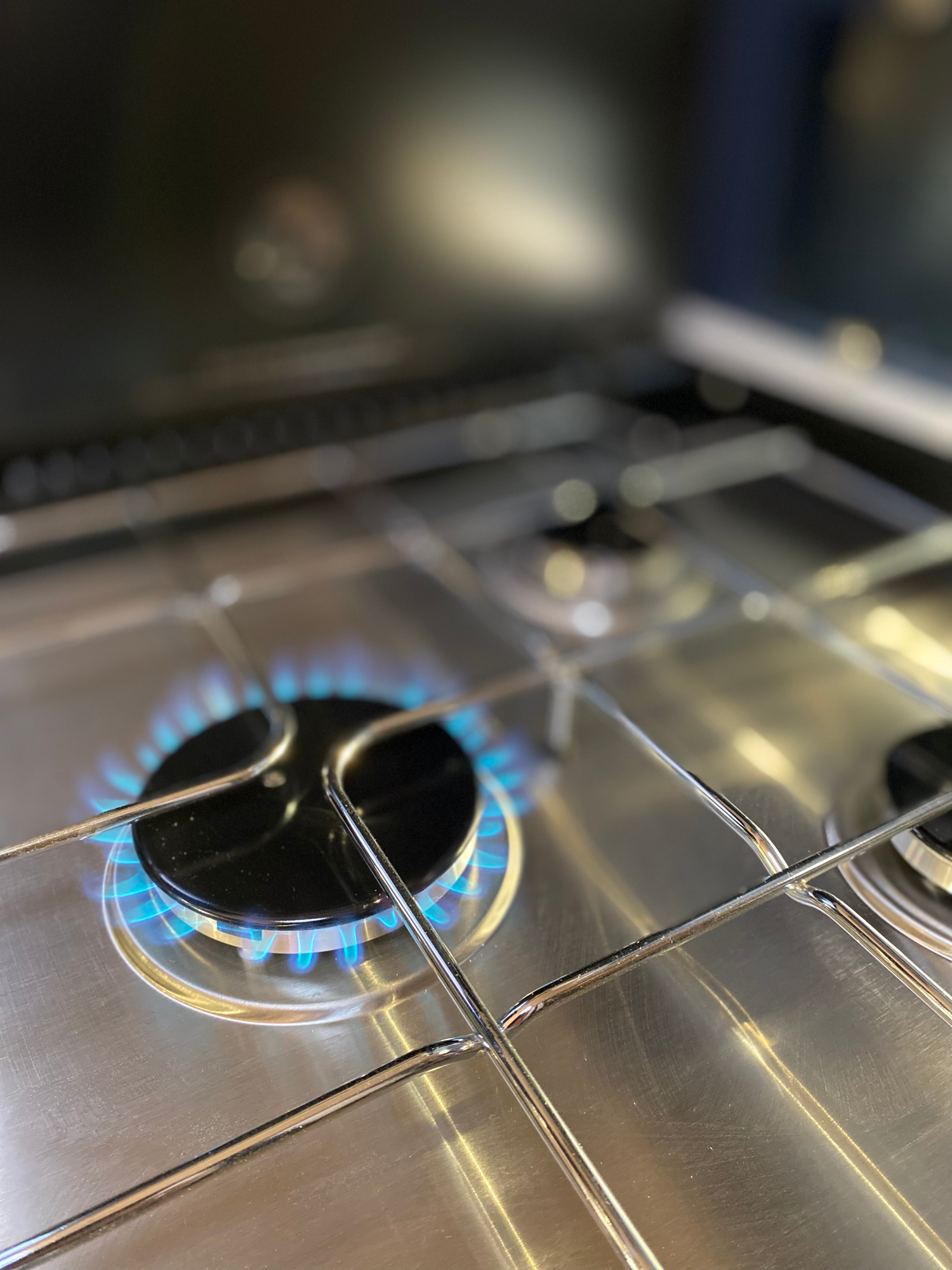 Gasherd mit leicht zu pflegender Edelstahloberfläche Gasherd mit brennenden Flammen auf einer Edelstahloberfläche.