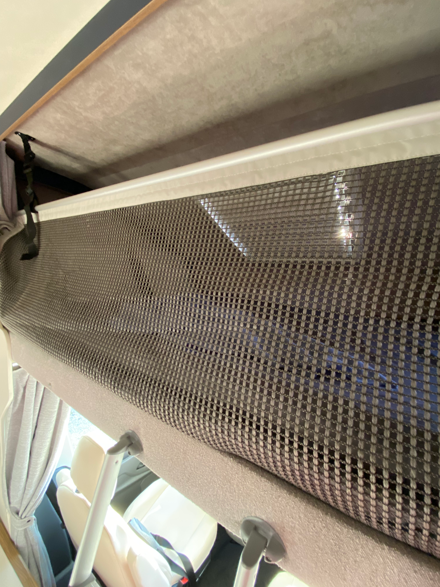 Einfach zu schließendes Schutznetz gegen Herausfallen Ein Netz-Organizer für Ablageflächen in einem Fahrzeug, sichtbar von der Seite.