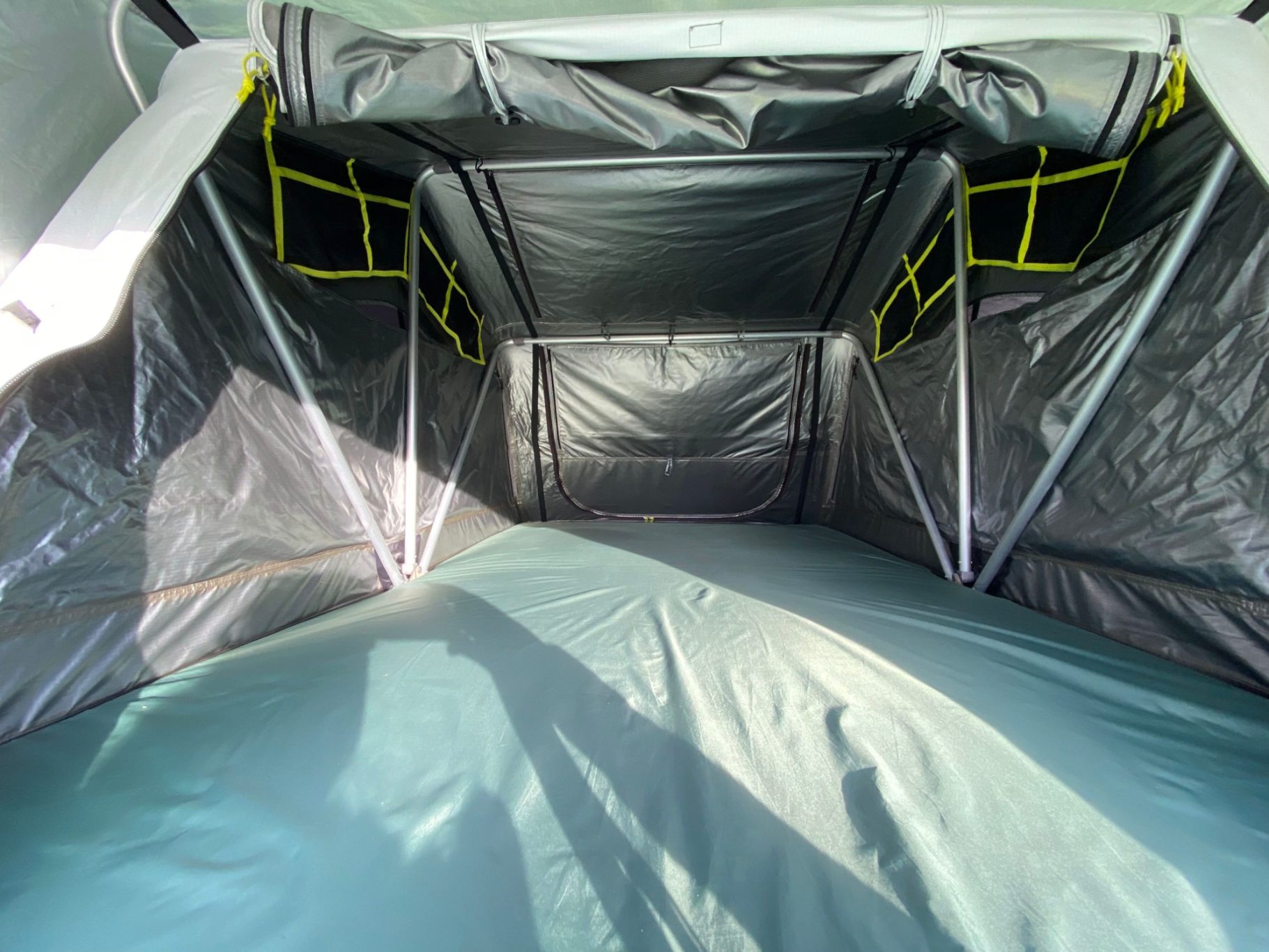 Dachzelt von innen Geräumiger Innenraum eines Zeltes mit grauen Wänden und gelben Netzen.