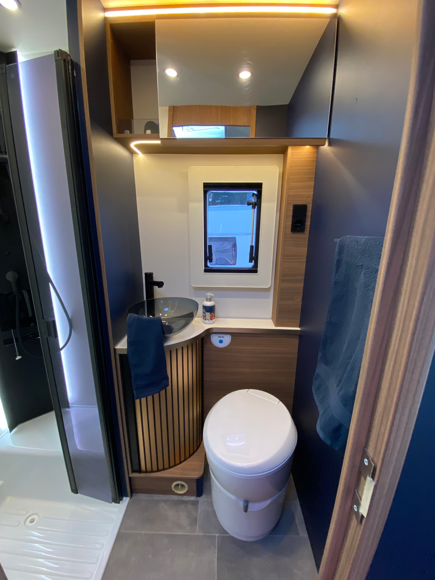 Das Bad mit Fenster Kompakte Badezimmeransicht mit Toilette, Waschbecken und Fenster.