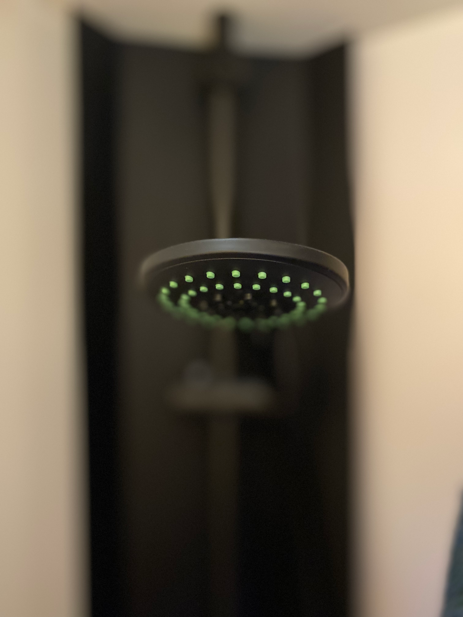 Moderne Dusche Duschkopf mit einem modernen, runden Design und grünen Wasserstrahlen.